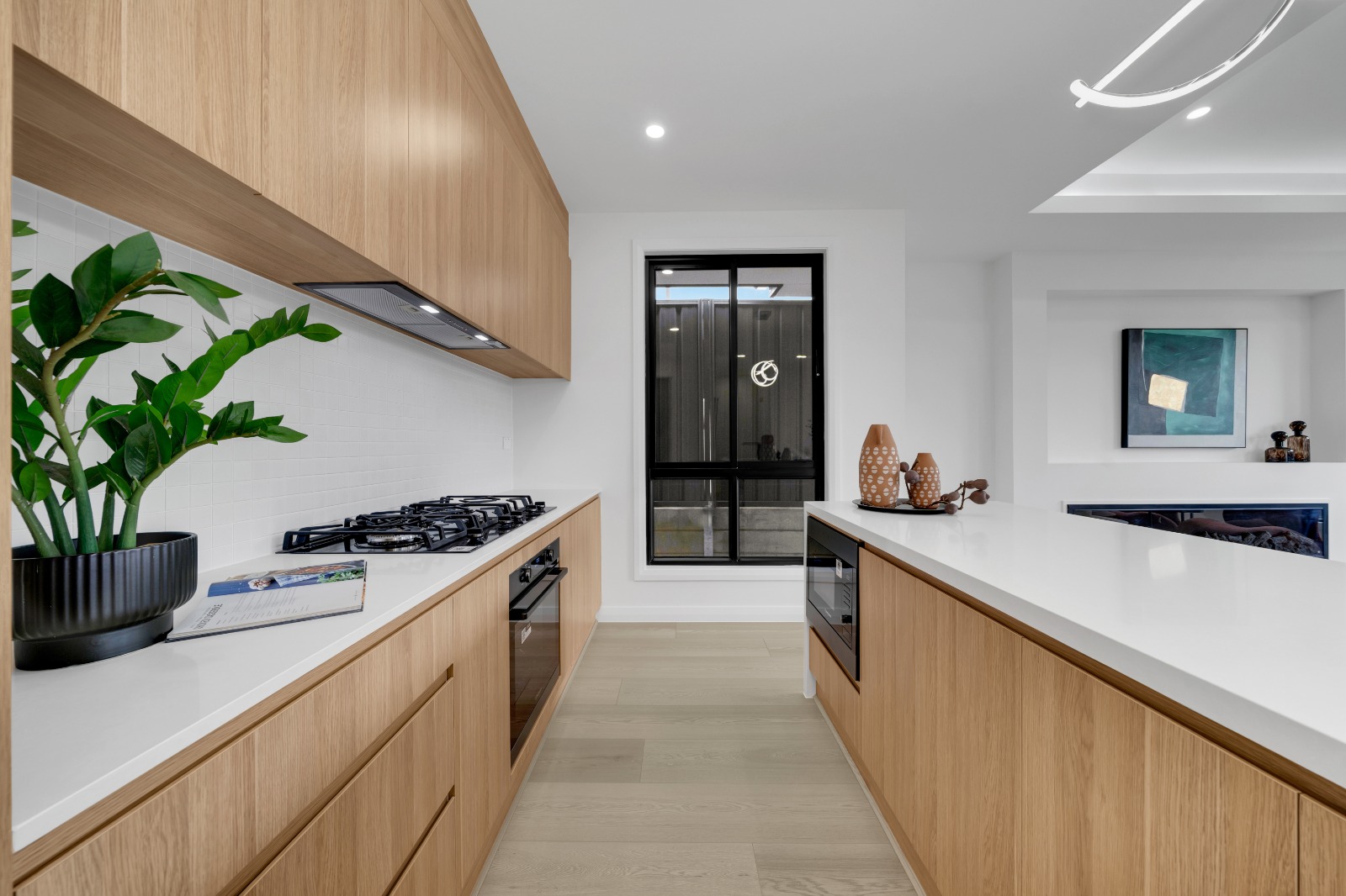 Kitchen with timber-look cabinetry, gas cooktop and stone benchtops