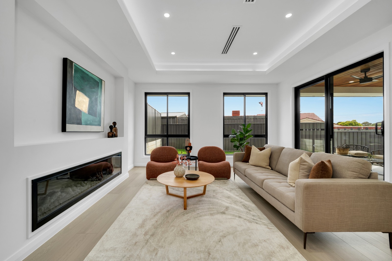 Living room with raised ceiling, built-in fireplace and sliding doors to the alfresco